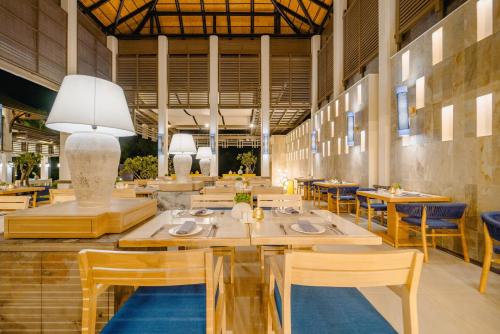 a dining room with wooden tables and chairs at Bhu Nga Thani Resort & Villas Railay in Railay Beach