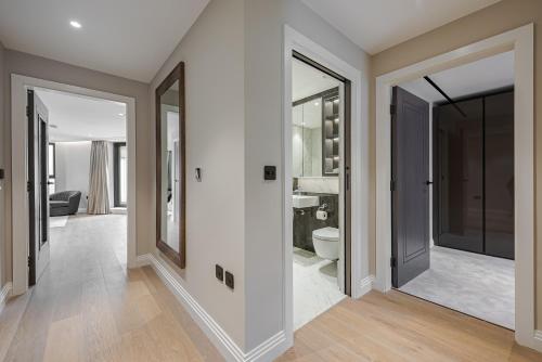 einen Flur mit einem Bad mit WC und Spiegeln in der Unterkunft Arcadia Residences - Luxury Apartments in Kensington in London