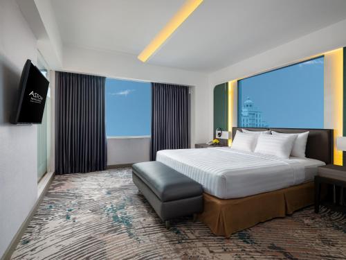 a hotel room with a bed and a large window at Aston Makassar Hotel & Convention Center in Makassar