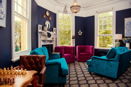 The Australian Heritage Hotel في سيدني: غرفة معيشة مع جدران زرقاء وكراسي ملونة