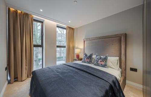 ein Schlafzimmer mit einem großen Bett mit Kissen in der Unterkunft Arcadia Residences - Luxury Apartments in Kensington in London