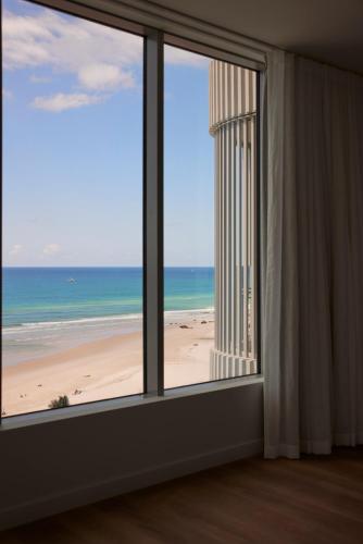 a room with a window with a view of the beach at Kirra Point Holiday Apartments in Gold Coast