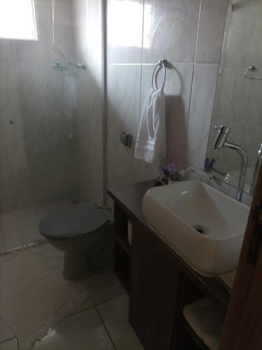 y baño con lavabo, aseo y ducha. en Cantinho Aconchego en Santo Antônio do Pinhal