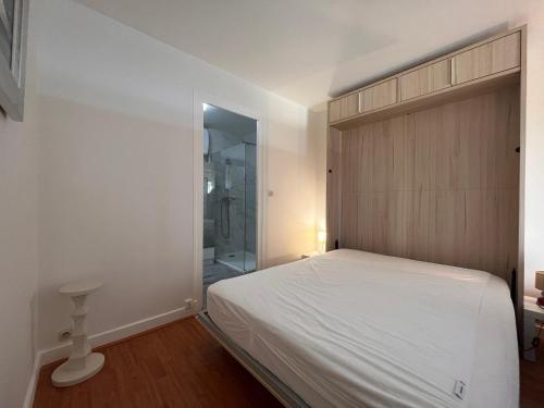een slaapkamer met een wit bed en een douche bij Appartement Saint-Jean-de-Luz, 1 pièce, 4 personnes - FR-1-239-858 in Saint-Jean-de-Luz
