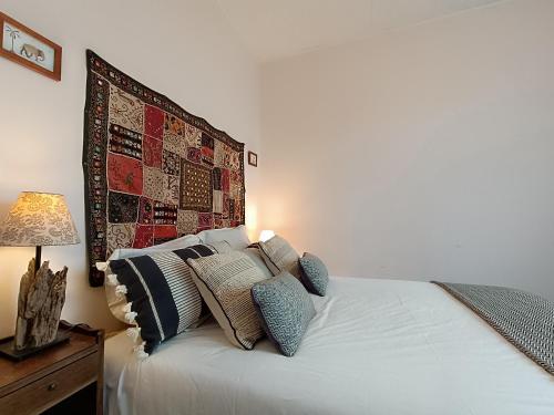 une chambre avec un lit avec des oreillers dessus dans l'établissement Maison Brévinoise, bien équipée, proche plage et commerces - 5 pers, 2 terrasses, parking - FR-1-364-90, à Saint-Brévin-les-Pins