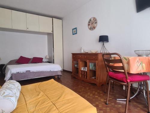 a bedroom with a bed and a chair and a desk at Studio avec parking, terrasse ensoleillée et tennis à Collioure - FR-1-309-234 in Collioure