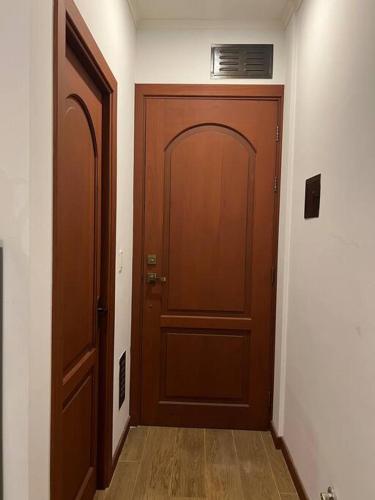 um corredor com duas portas de madeira num quarto em Cómodo céntrico y acogedor apartamento em Tarija