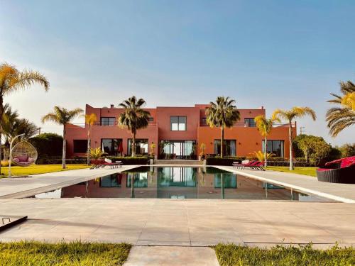 a house with a swimming pool in front of a building at Villa Dar El Hna in Marrakesh