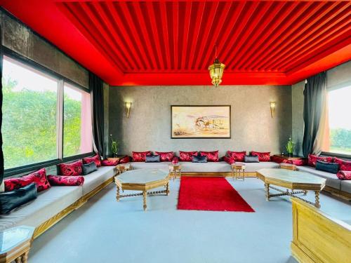 een woonkamer met rode kussens en een rood plafond bij Villa Dar El Hna in Marrakesh