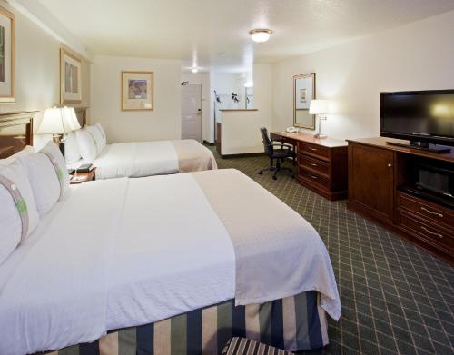 a hotel room with two beds and a flat screen tv at Holiday Inn Redding, an IHG Hotel in Redding