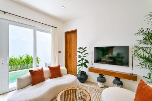 a living room with a couch and a large window at Elena Villa by Betterplace in Tanah Lot