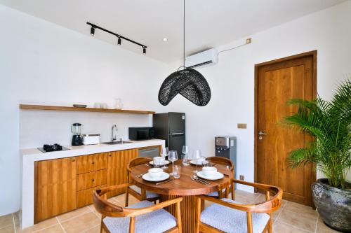 a kitchen and dining room with a wooden table and chairs at Elena Villa by Betterplace in Tanah Lot