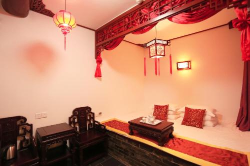 a room with two beds and two chairs at Pingyao Ji Family Courtyard Inn in Pingyao