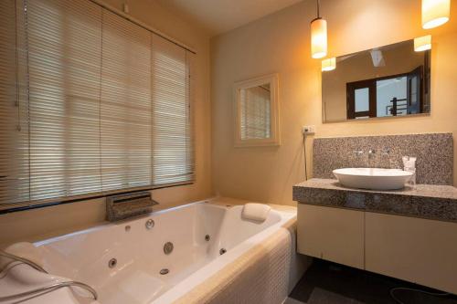 een grote badkamer met een bad en een wastafel bij Summer Dream 3-Bedroom pool villa in Ban Saiyuan (1)