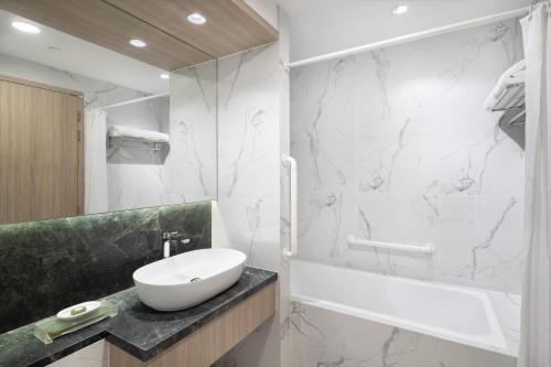 a bathroom with a sink and a tub and a toilet at Park Avenue Clemenceau in Singapore