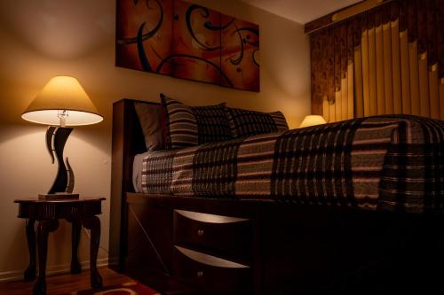 1 dormitorio con cama y mesita de noche con lámpara en Spacious Comfy Room in Cozy Classy Duplex en Brooklyn