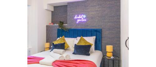 倫敦的住宿－Urban Spectrum: Vibrant Studio with Kitchenette，卧室配有一张墙上紫色标牌的床