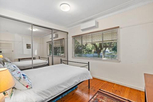 a bedroom with two beds and a window at King Parrot in Pearl Beach