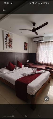 um quarto com uma cama grande e almofadas vermelhas em Quince mysore em Mysore