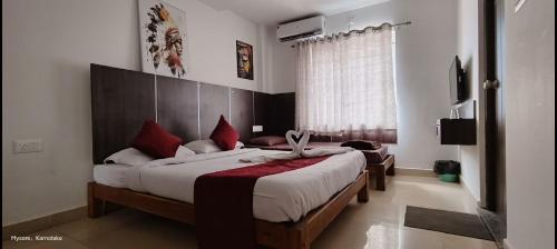 1 Schlafzimmer mit 2 Betten und roten Kissen in der Unterkunft Quince mysore in Mysore