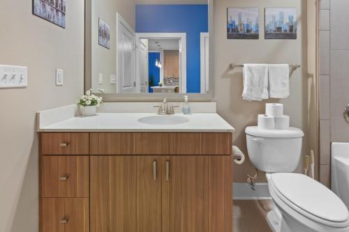 a bathroom with a sink and a toilet and a mirror at City Living in Downtown Raleigh Luxury Apt 1 in Raleigh