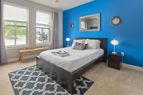 um quarto azul com uma cama e um espelho em City Living in Downtown Raleigh Luxury Apt 1 em Raleigh