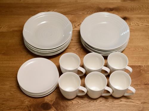 a group of white cups and plates on a table at Rakuten STAY HOUSE x WILL STYLE Sasebo in Sasebo