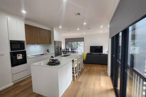 a kitchen and living room with a white counter top at Spacious & Modern 4 Bedrooms in Tuggeranong