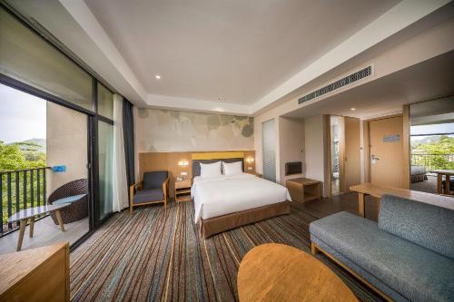 a hotel room with a bed and a balcony at Holiday Inn Express Emei Mountain by IHG in Emeishan
