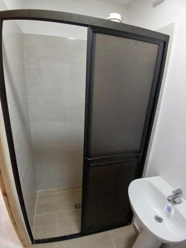 a shower with a glass door next to a sink at Apartaestudio Rionegro cerca Aeropuerto in Rionegro