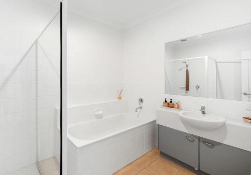 een witte badkamer met een bad en een wastafel bij Penthouse Esplanade Cowes - Beach Front - Sea View in Cowes