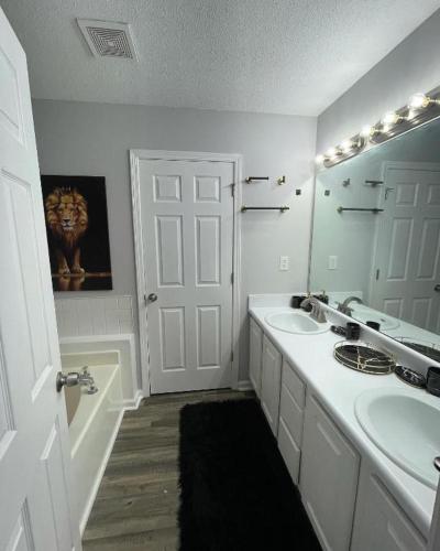 a white bathroom with a sink and a mirror at Pressure Pad in College Park