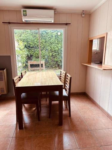 坦迪尔Duplex del Parque的一间有桌子、椅子和窗户的餐厅