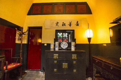 a room with a dresser and a lamp in a room at Pingyao Ji Family Courtyard Inn in Pingyao