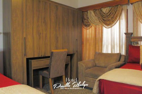 1 dormitorio con escritorio, silla y cama en Hotel Pasillo Rholyn, en Antigua Guatemala