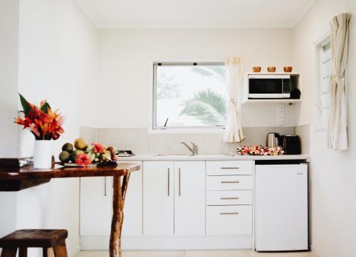 uma cozinha com armários brancos e uma janela em Tai Marino - Beach Bungalows em Amuri