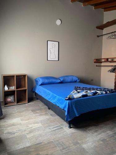 Un dormitorio con una cama con sábanas azules. en MAGICO APARTA ESTUDIO BELEN FATIMA, en Medellín