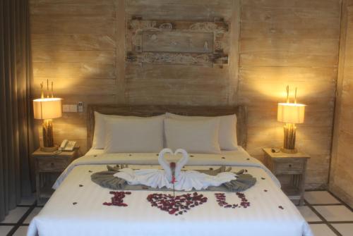 a bedroom with a bed with two lamps on it at Umaya Ubud Villa in Ubud