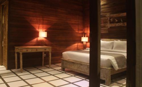 a bedroom with a bed and a table with two lamps at Umaya Ubud Villa in Ubud
