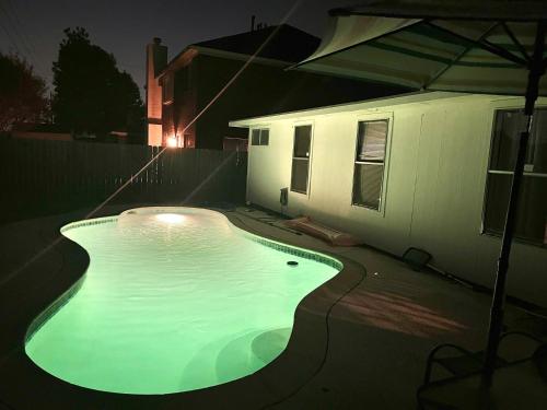 a swimming pool in front of a house at night at David &Jennie’s Place I in Missouri City