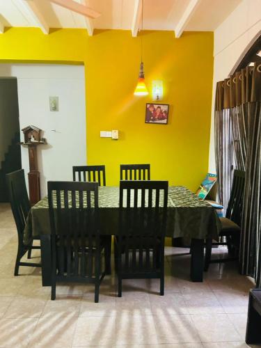 a dining room with a green table and chairs at Keran villa in Wadduwa