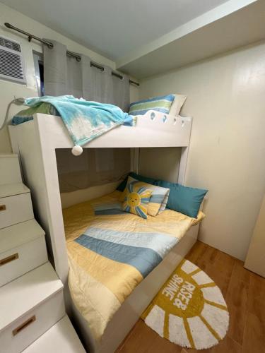 a bunk bed in a small room with a bedsheet at Micairan Suite in Davao City