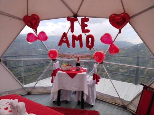 a room with a table with hearts and a i am sign at Hotel Campestre Mirador De San Nicolas in Ubaque
