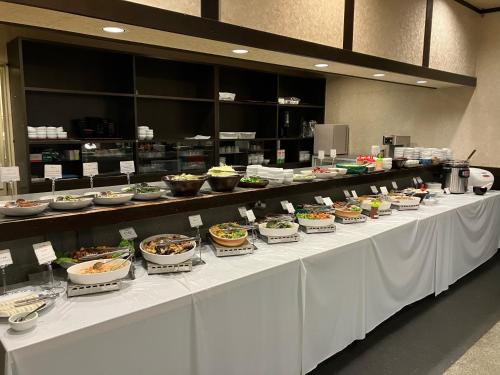 uma linha de buffet com tigelas de comida numa mesa em Hotel Alpha-One Tokuyama em Shunan
