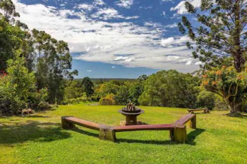 a park bench in the middle of a field at Noosa Hinterland Escape in Black Mountain