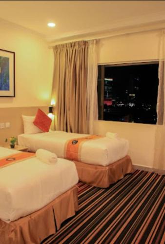 a hotel room with two beds and a window at hotel bintang in Kuala Lumpur