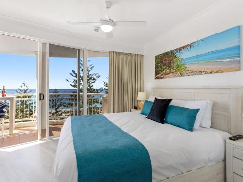 a bedroom with a bed with a view of the beach at ULTIQA Burleigh Mediterranean Resort in Gold Coast