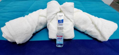- Botella de pasta de dientes y toallas en la cama en Beautiful Newer Scalea Beach Apartment en Scalea