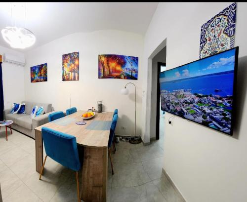 comedor con mesa y TV en la pared en Beautiful Newer Scalea Beach Apartment en Scalea