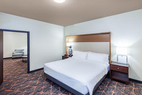 a hotel room with a bed and a chair at Holiday Inn & Suites Stillwater-University West by IHG in Stillwater